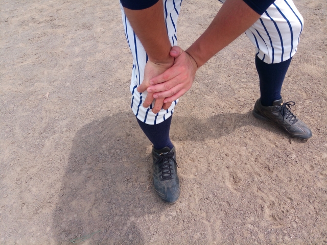 野球の練習中に膝が痛み悩む男性